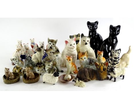 A collection of ceramic cats, to include a Wade examples, Royal Doulton Siamese cat, Staffordshire type cats, three sheep etc