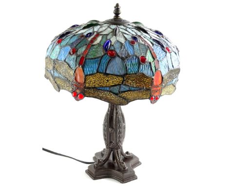 A Tiffany style lamp, the shade decorated with glass cabochon dragonflies etc., the bronzed base with a bullet shaped column,