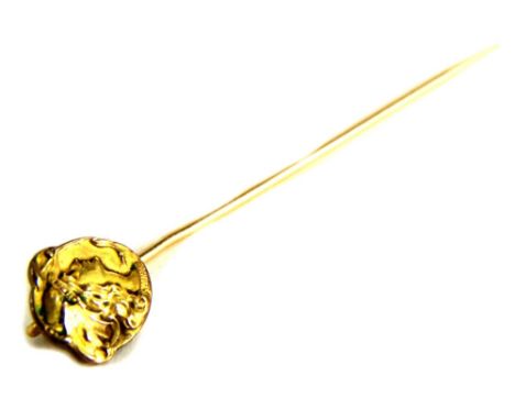 An Art Nouveau stick pin, with circular head depicting a maidens head, yellow metal, unmarked, 6cm long. 