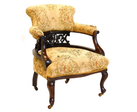 An early 20thC mahogany tub shaped chair, upholstered in tapestry style fabric to the back and seat, on cabriole legs with ca