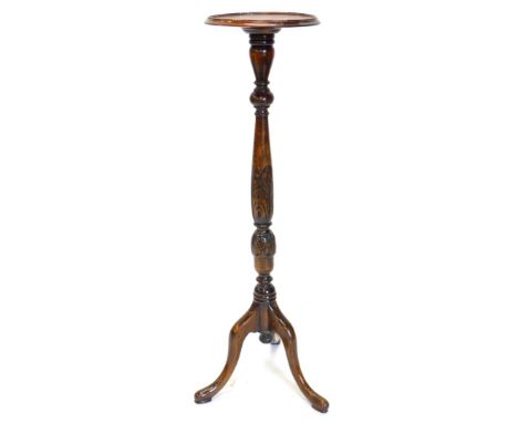 A mahogany torchere or plant stand, the circular dished top on a leaf carved turned column and tripod base with pad feet, 107