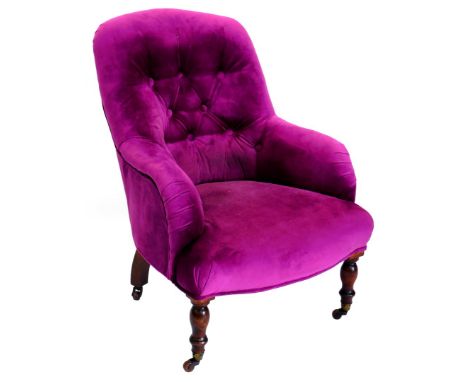 A Victorian mahogany armchair, upholstered in buttoned vivid purple fabric, on turned legs with ceramic castors.