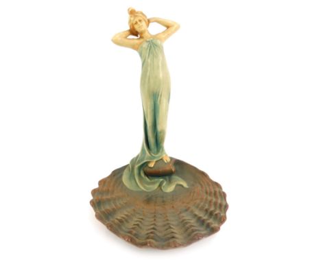 An early 20thC Art Nouveau Bernard Bloch pottery figure, of a standing lady atop a scallop shell, designed by R Dubitzky, mod