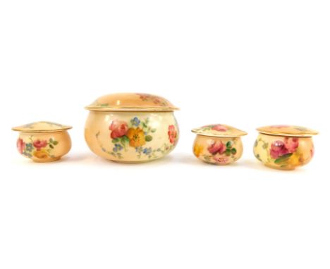 A group of four Royal Worcester blush porcelain dressing table and ointment jars and covers, painted with flowers, printed ma
