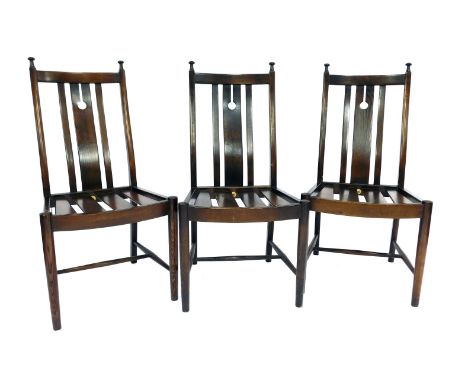 A set of three Ercol dark elm dining chairs, with two tie on cushion seats. 