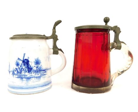 Two early 20thC tankards, comprising a Bohemian ruby glass example, the lid decorated with horse and jockey in a stable, 15cm