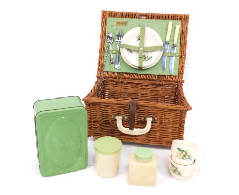 A Brexton picnic hamper, comprising ceramic dinner set with Snow Bell pattern and green and cream tupperware, in wicker carry