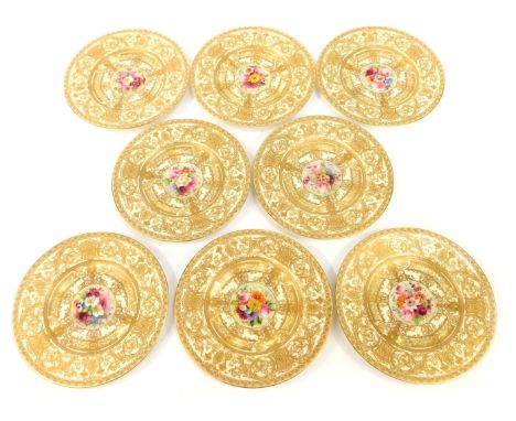 A set of eight late 19thC Royal Worcester cabinet plates, each on a cream ground, with heavy gilt floral detail, and a painte