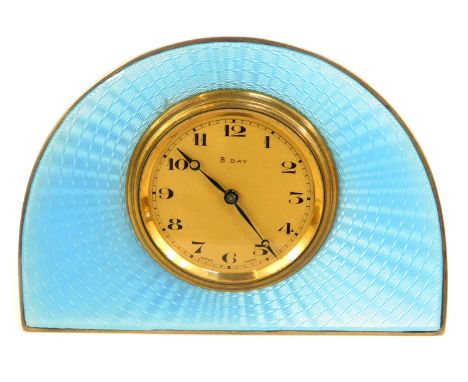 An Art Deco white metal travelling clock, the arched form set with blue enamel, the case unmarked, with eight day brass movem