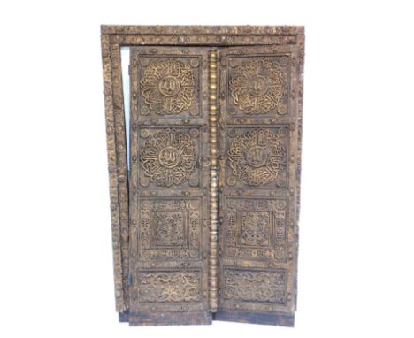 A pair of late 19th/early 20thC Eastern doors, each carved with roundels, leaves, etc., and with gilt drop handles, and a fir