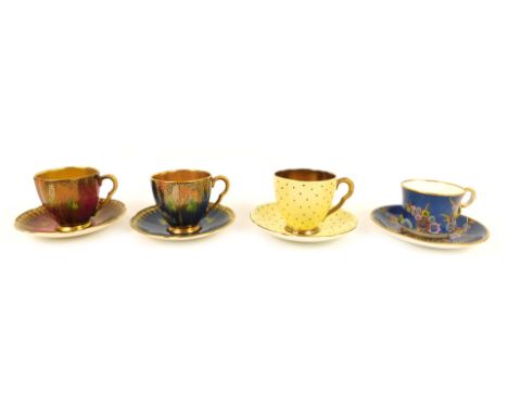 Four Carltonware coffee cups and saucers, comprising a blue ground coffee cup and saucer, decorated with birds and trees, a r