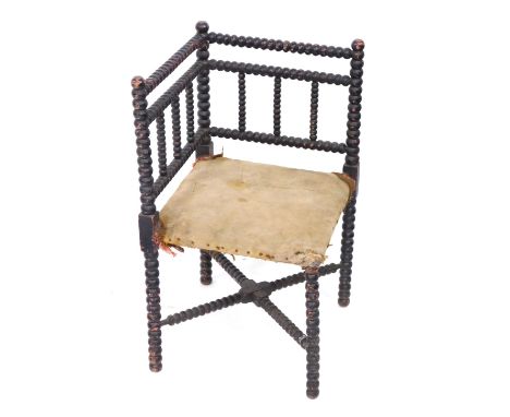 A late 19thC ebonised bobbin turned corner chair, with X stretcher. 