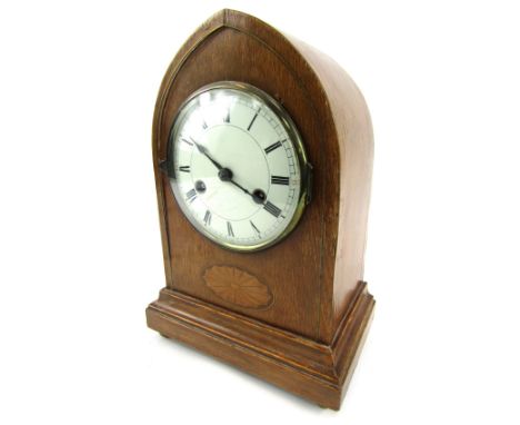 An Edwardian mantel clock, in oak case with boxwood fan inlay, with a white ceramic Roman numeric dial, with thirty hour move