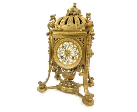 An early 20thC French brass mantel clock, with rococo scroll casing, with crown top, with dragon borders, with circular white