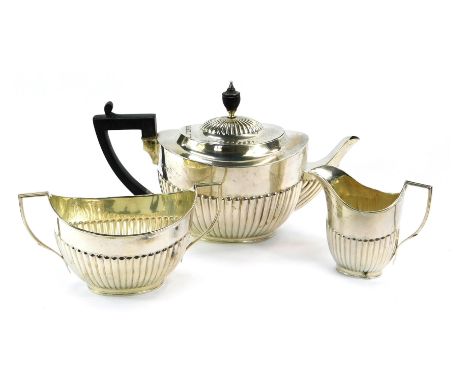 An Edward VII silver three piece tea service, with ebonised handles and knop, with fluted design, London 1901, 30¾oz. 