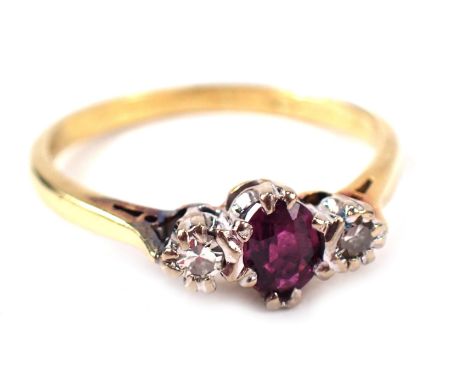 An 18ct gold ruby and diamond dress ring, central oval cut ruby, flanked by two round brilliant cut diamonds, each in claw se