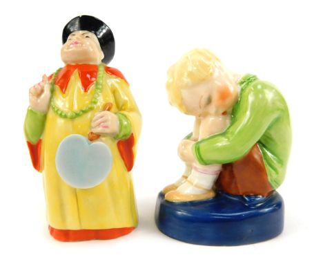 A Royal Worcester porcelain candle snuffer, circa 1923, modelled as a china man, standing holding a fan, printed marks, and a