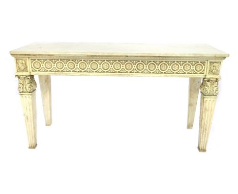 A Neoclassical style marble topped and cream painted console, with a floral carved frieze, raised on leaf carved and fluted t