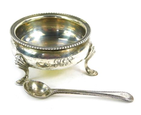 A George V silver salt and later spoon, the salt with tripod base, bearing the initials HGS, London 1934, 1.77oz. (2) 