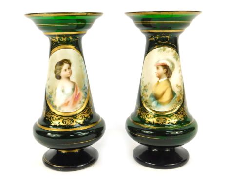 A pair of 19thC Bohemian green glass vases, each with a gilt fluted rim, with an oval painted portrait panel, one depicting f