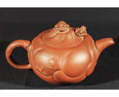 A Chinese pottery teapot with swirling dragon design