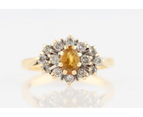 An 18ct yellow gold orange sapphire and diamond cluster ring, set with a central orange sapphire, surrounded by two tiers of 