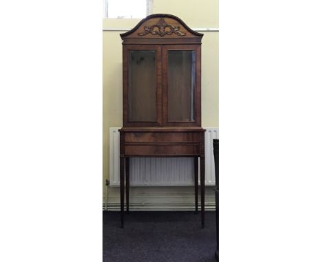 A mahogany reproduction display cabinet with fitted drawers and tapering legs.