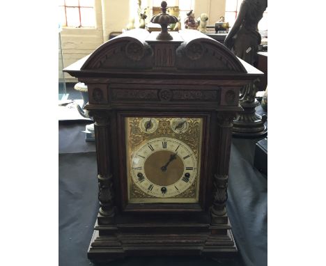 A large oak cased bracket clock, brass and enamel dial with fluted column front.