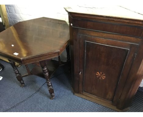 An oak corner cabinet together with an occasional table.