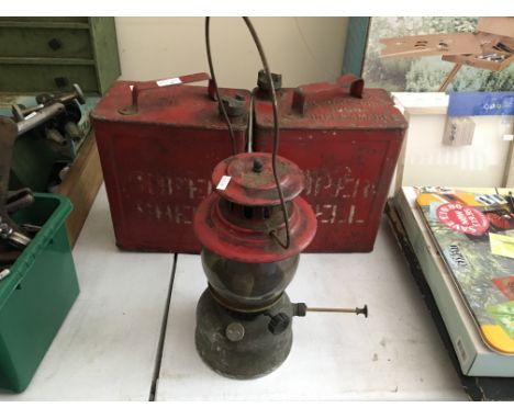 A paraffin lamp with two “SM and BP Ltd petrol cans
