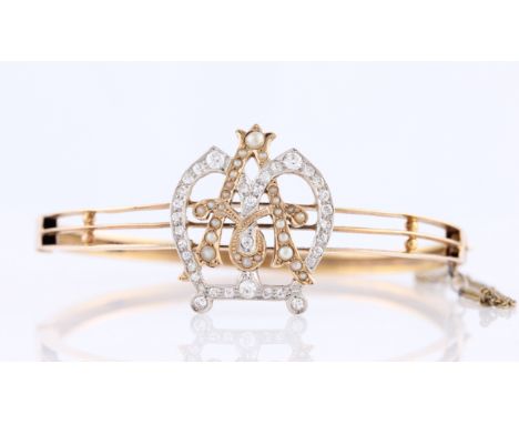 An early 20th Century Australian diamond and pearl hinged bangle, featuring a pearl set 'A' within an old cut diamond set cor