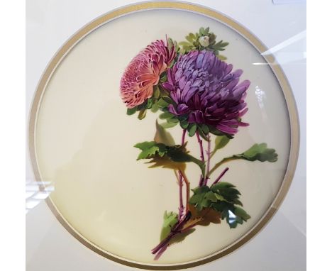 A pair of signed framed ceramic wall plates with floral decoration.