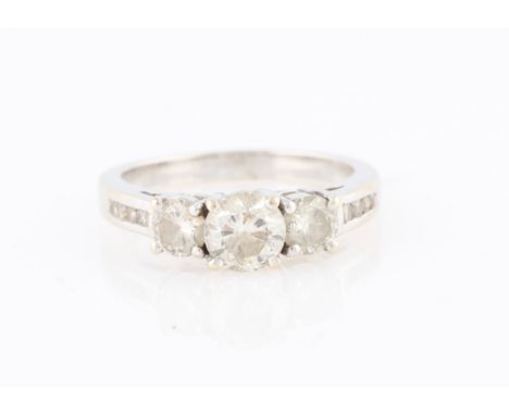 A diamond ring, set with three principal round brilliant cut diamonds, measuring approx. 1.10ct total, with four channel set 