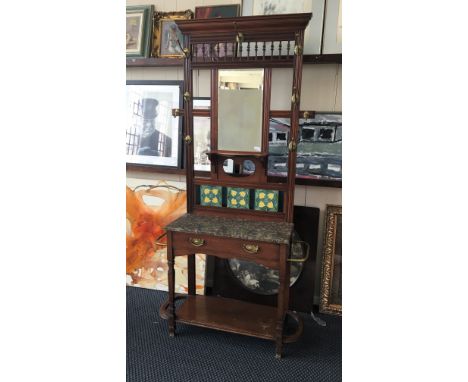 A mahogany hall hat and coat stand with marble shelf and three tulip decorated tiles