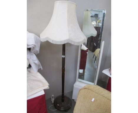 A wooden standard lamp with shade