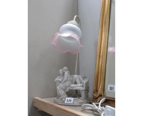 A figural table lamp featuring a couple