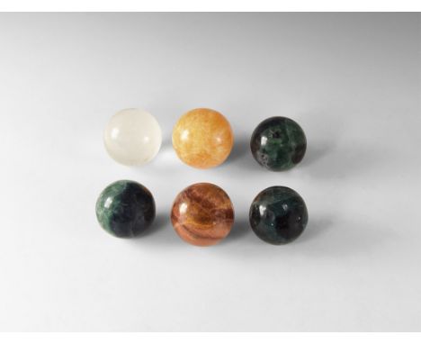 A group of six polished mineral spheres comprising of three green and purple fluorite, one translucent quartz, one red agate,