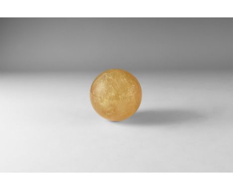 A polished sphere of yellow-brown 'citrine' calcite with reflective internal features. 400 grams, 65mm (2 1/2"). From the his