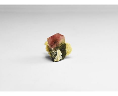A large, well terminated tourmaline with striated sides with a pink, clear and green colour in bands, set within a matrix of 
