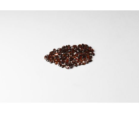 A group of one hundred oval-cut garnets of a deep red-brown colour. 22 grams total (110 carats), approximately 7mm (2 3/4"). 