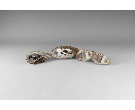 A group of four cut and polished agate geodes with bands of brown, white and black colour. 585 grams total, 6.5-11.5cm (2 1/2