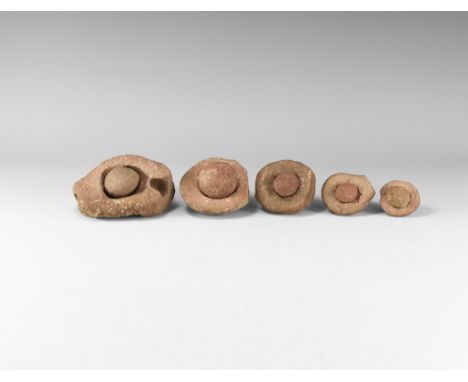 Group of five wind-rounded pebbles with their individual hollowed out 'nests', from the Kalahari Desert region, western Afric