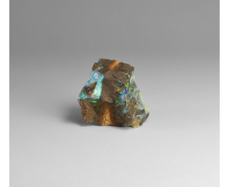 A block of red-brown sandstone with areas of precious opal diffracting light in primarily purples, blues and greens, in white