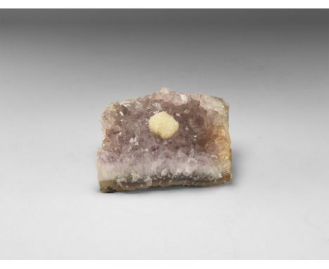 A section of amethyst crystals in a matrix with pale purple colour with central white crystalline cube. 531 grams, 10cm (4").