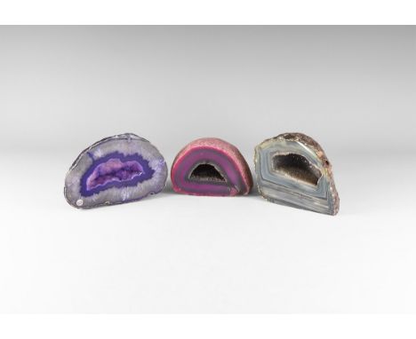 A mixed group of polished agate geodes comprising of a dark purple, banded blue and pink specimens; each with quartz crystals