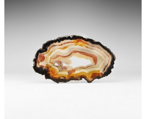 A large cut and polished agate slice with bands of dark and pale brown, with central cavity filled with crystals. 443 grams, 