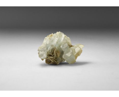 A light blue, well-formed lustrous aquamarine crystals with accessory muscovite crystals, in old white card tray and label 'A