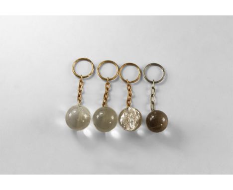 A group of four cut and polished quartz spheres, each with a short chain suspender and split keyring fitted. 141 grams total,