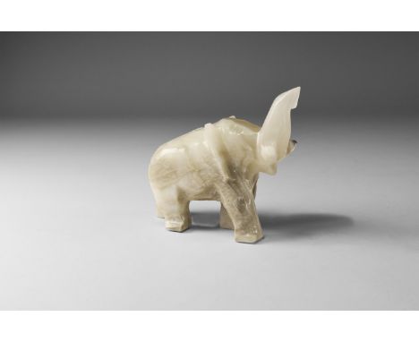 A carved elephant statuette from a banded white and brown onyx, with label reading: 'Made in Mexico'. 258 grams, 85mm (3 1/4"