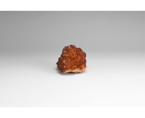 A fine specimen of a globular matrix with dark orange citrine crystals to the most of a surface, in white card tray with labe